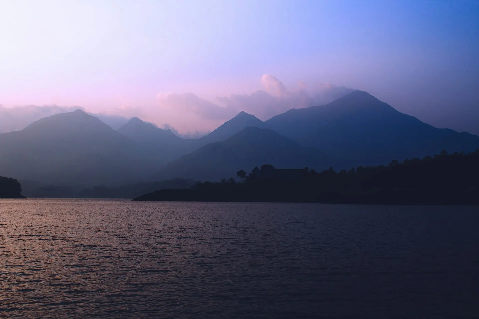 silhouette of mountains near body of water during daytime