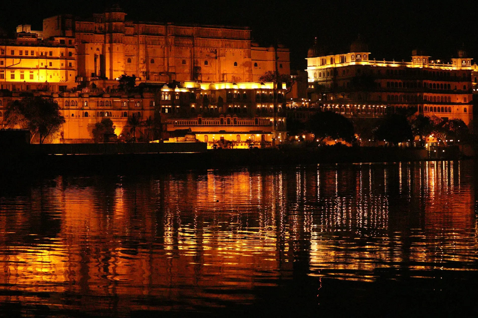 brown concrete building near body of water during night time