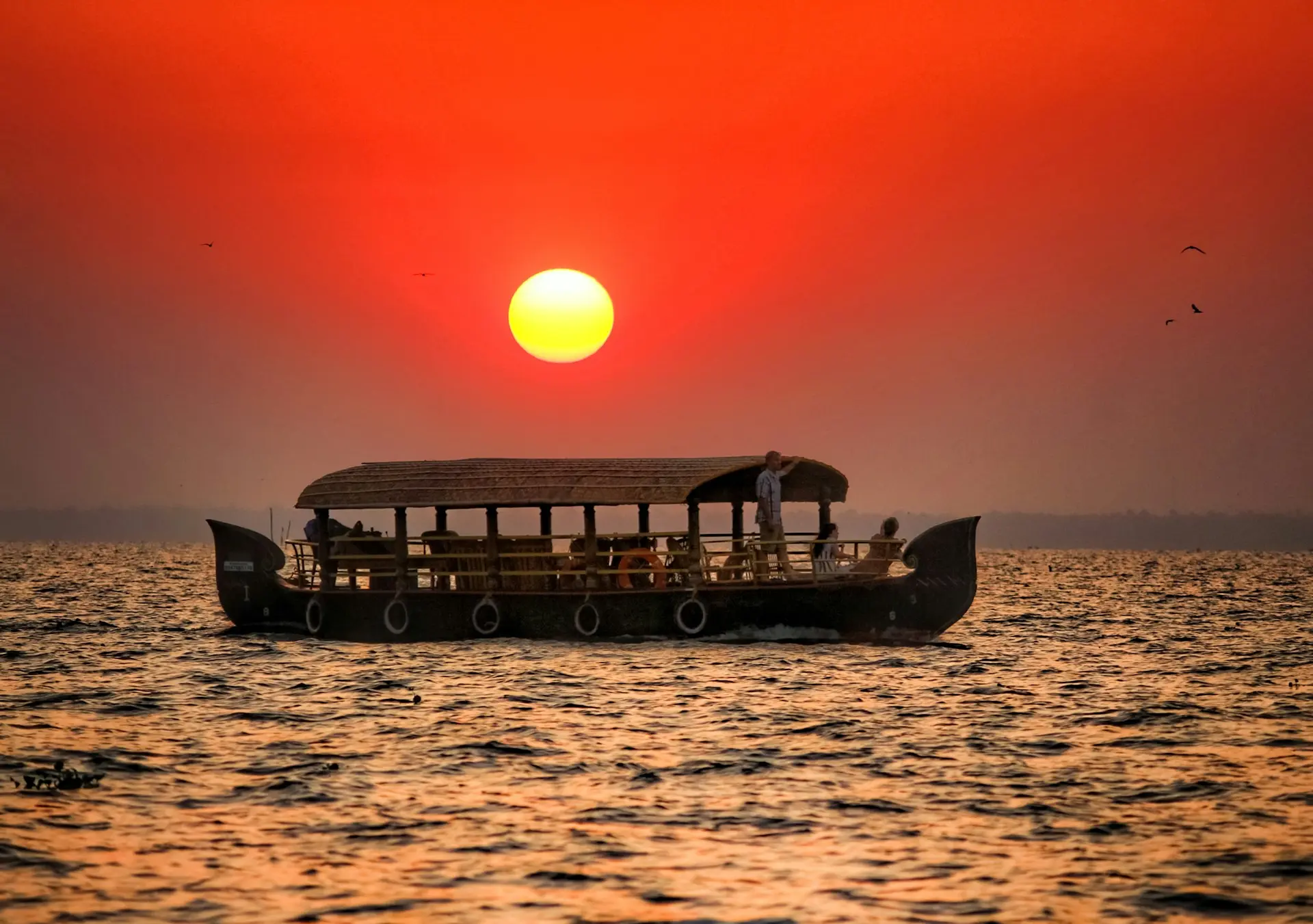 silhouette of boat on sea during sunset