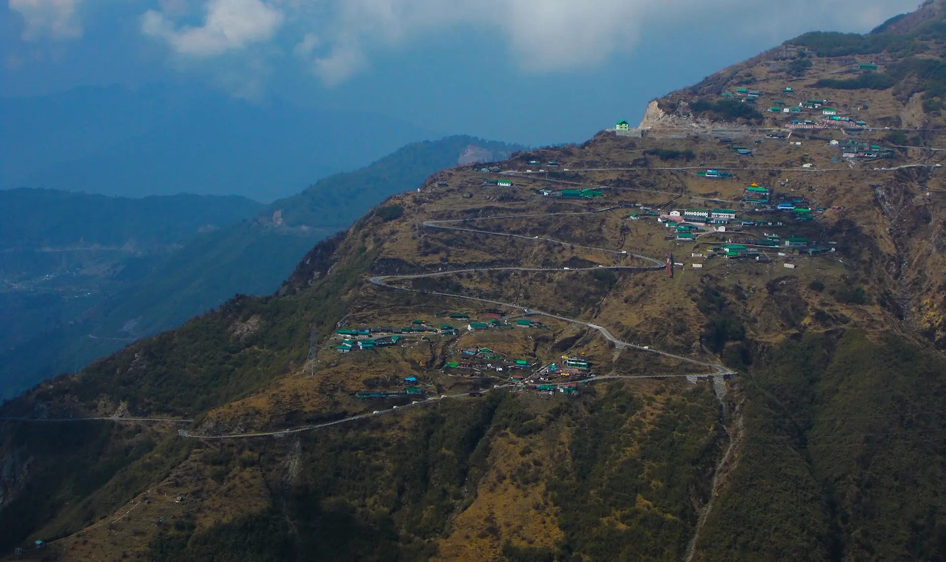 houses on mountain under blue sky during daytime