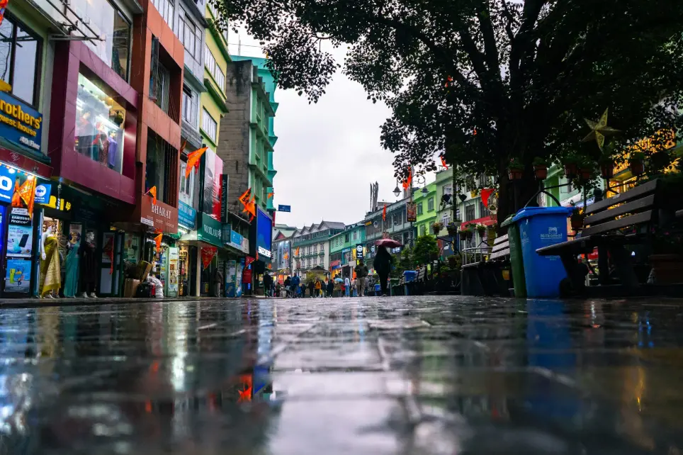 a wet street with people walking down it