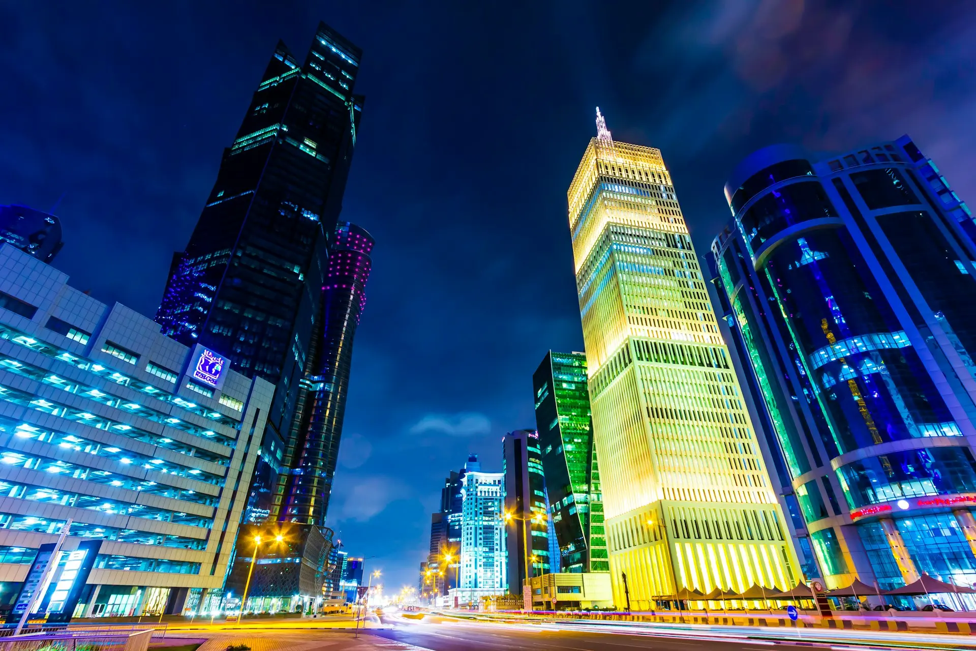 a city street at night with tall buildings