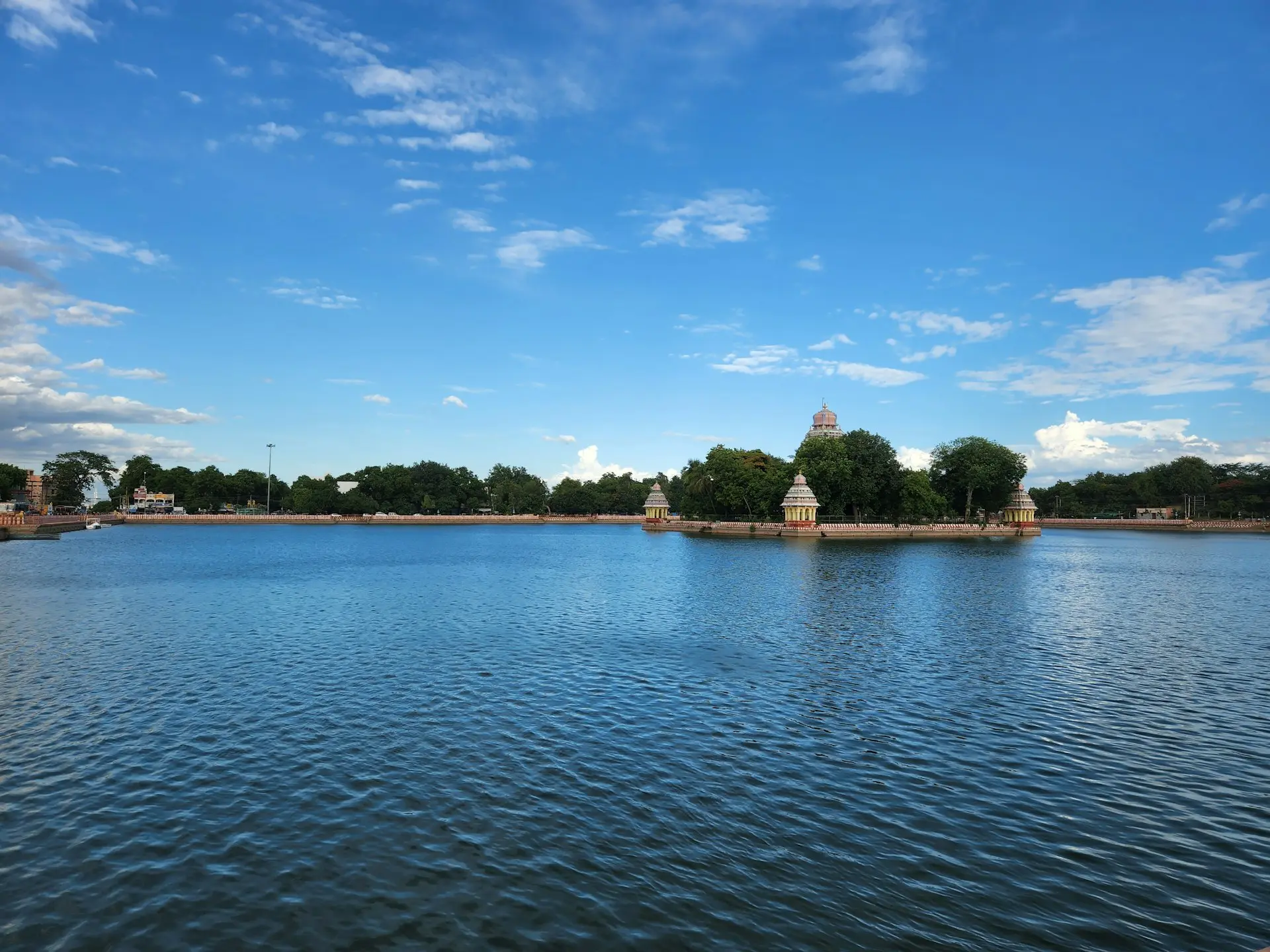 a body of water with trees and buildings in the background