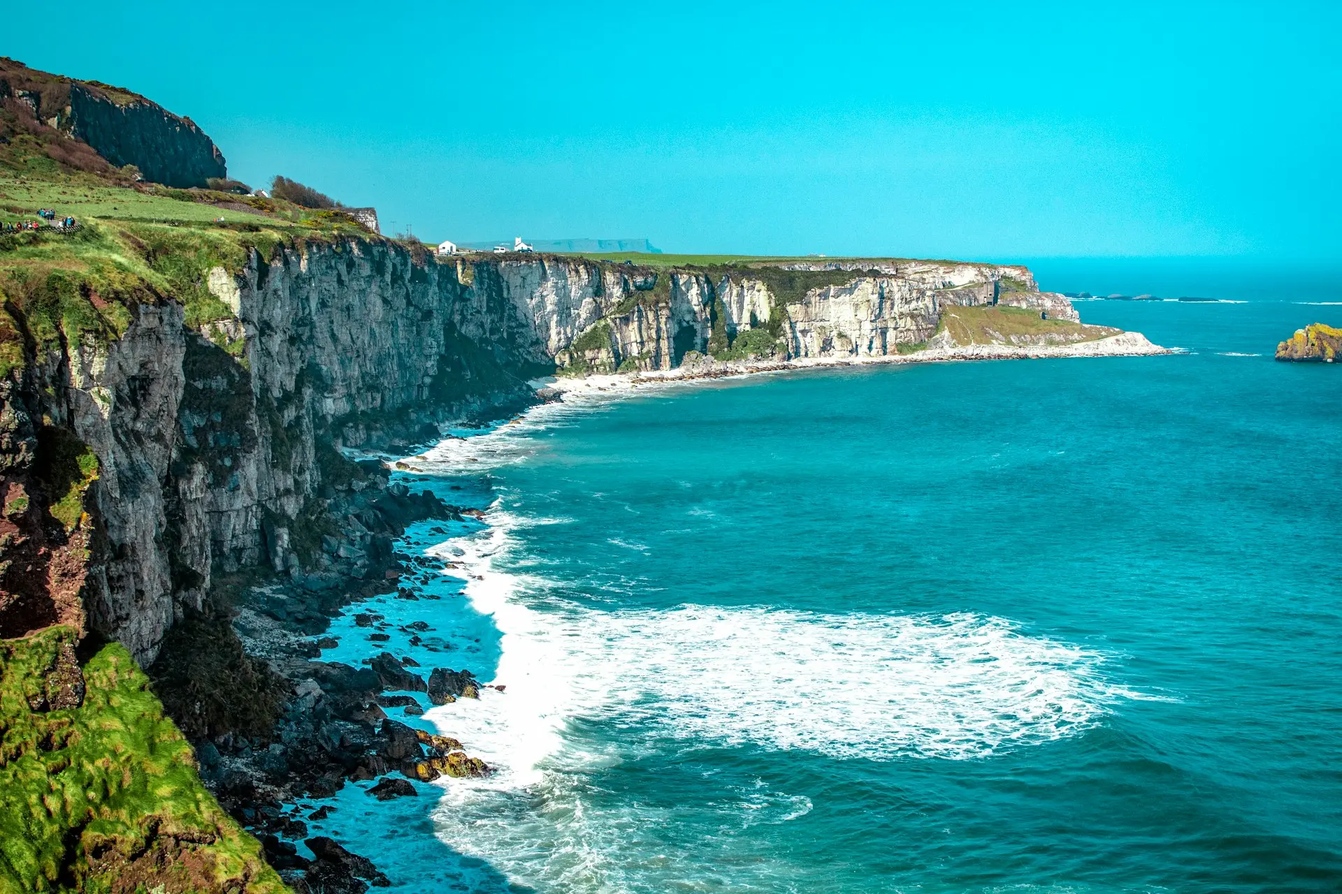 white rock cliff beside body of water'