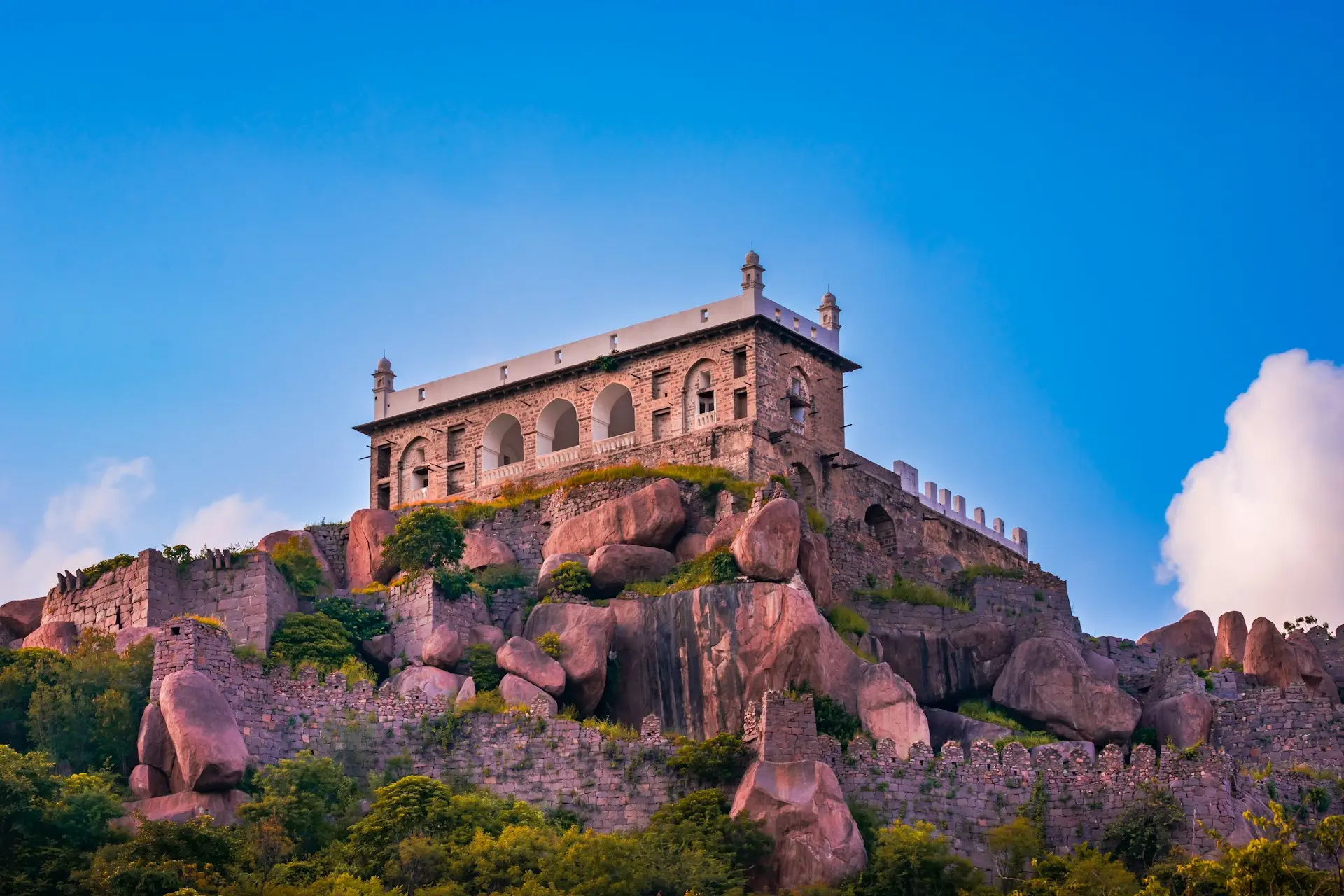 low-angle photography of brown castle on cliff under blue sky